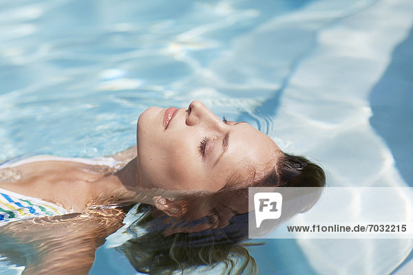 Mid-Adult Woman Floating in Swimming Pool