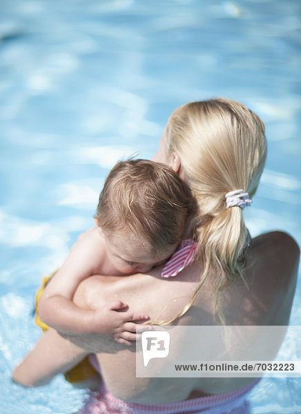 Mother Carrying Baby Boy in Swimming Pool