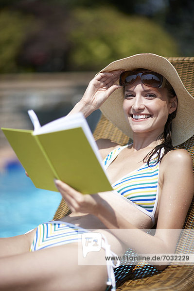 Happy Woman Reading Book by Pool