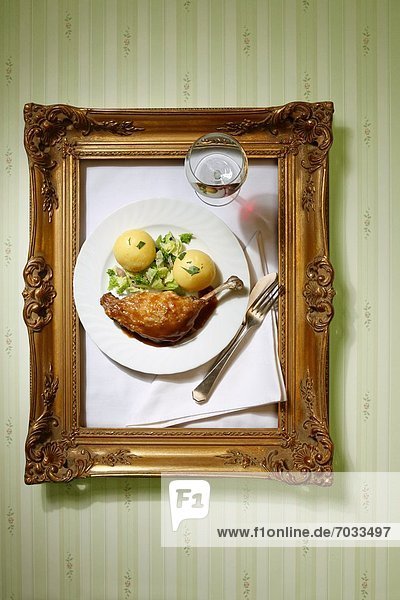 Plate with canard joint and dumping hanging in golden frame at the wall