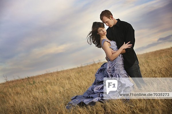 Couple Embracing In Middle Of Field