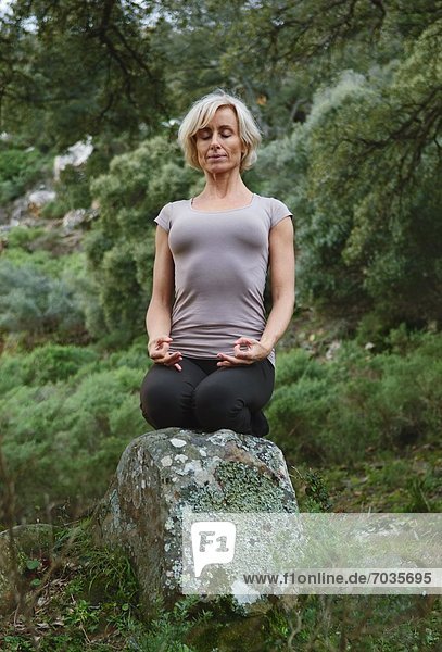 Mature Woman In Yoga Position In Forest