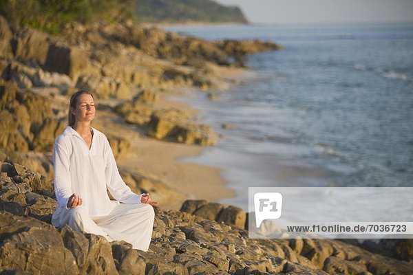 Woman Meditating On A Rocky Beach  Ko Lanta  Thailand