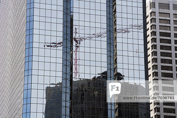 Construction Crane Seen In Reflection Of Modern Office Tower  Calgary  Alberta  Canada