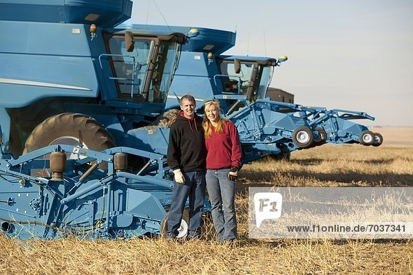 'Farming Couple With A Row Of Farm Machinery