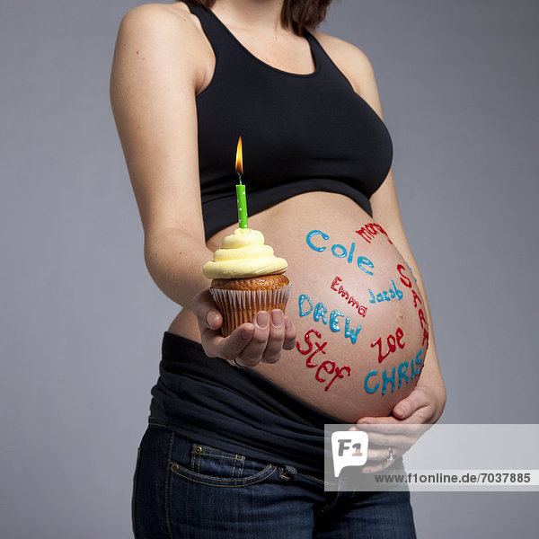 beleuchtet  Frau  schreiben  über  halten  Schwangerschaft  Kerze  nackt  Name  cupcake  Baby
