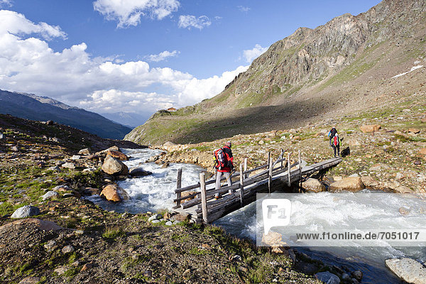 Hikers during the descent from Zufallferner Glacier to Marteller Huette hut  at the rear  in the Martell Valley  Alto Adige  Italy  Europe