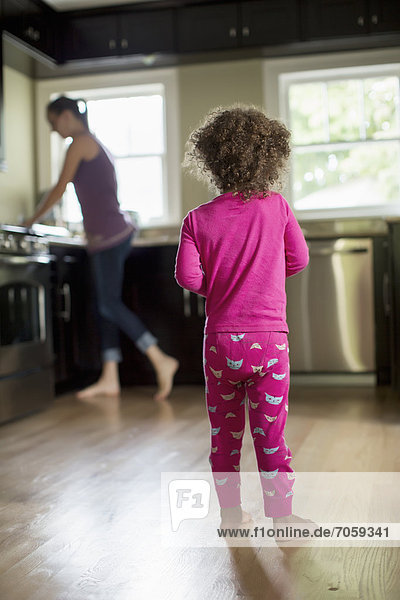 Mother and daughter standing in kitchen