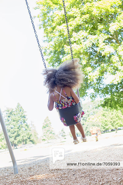 Mixed race girl swinging