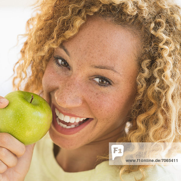 Portrait of smiling young woman with apple