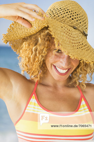 Portrait of smiling young woman in sun hat