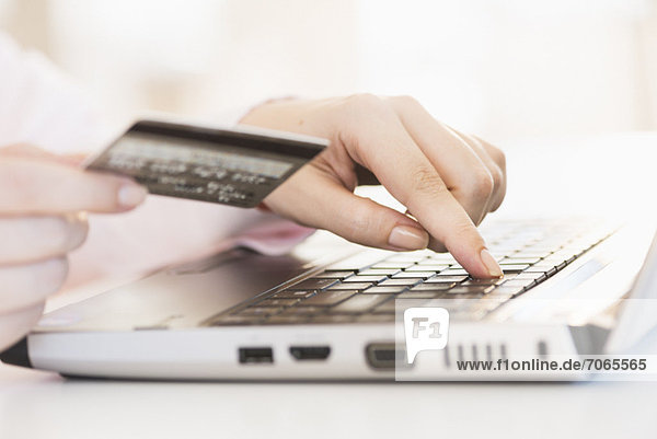 Close up of woman's hand doing online banking with laptop