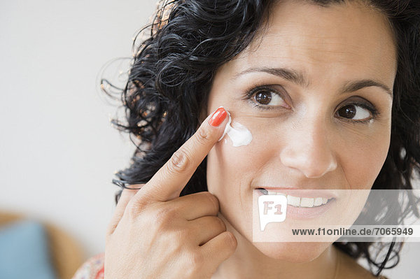 Mature woman applying anti-ageing cream