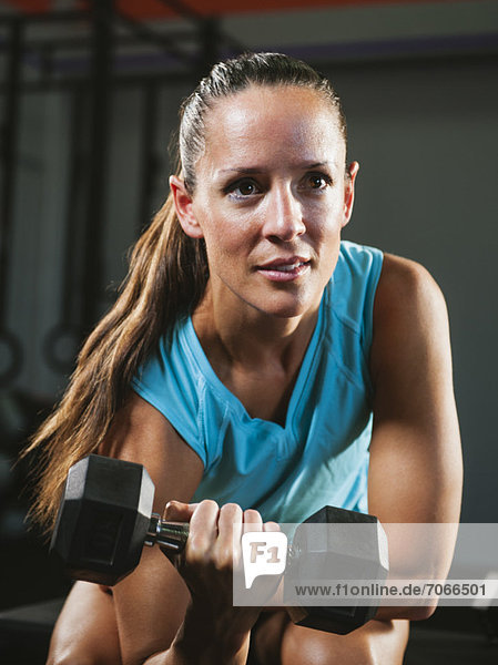 Mid adult woman exercising with dumbbells