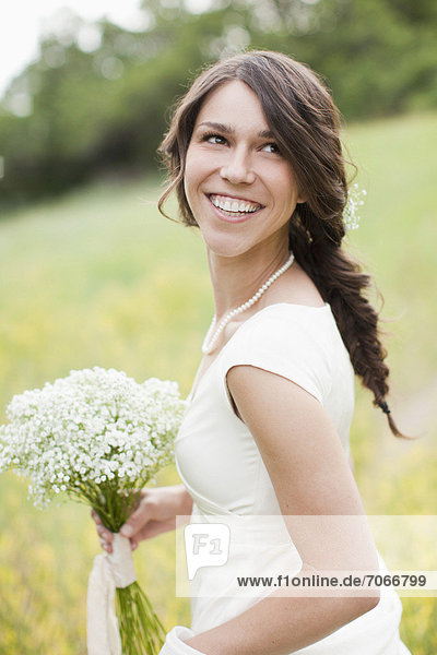 Portrait of happy woman holding flowers and smiling