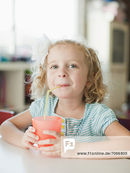 Portrait of girl drinking through straw