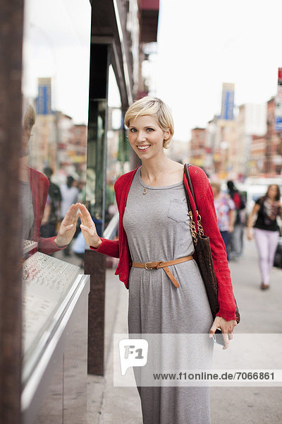 Portrait of woman standing by shop