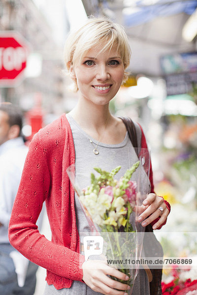 Portrait of smiling Frau hält Blumenstrauß