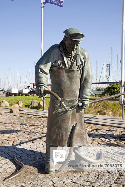 'Bronzestatue ''Peter Aal'' mit seinem Aalstecher am Hafen von Maasholm  Schleswig-Holstein  Deutschland  Europa'