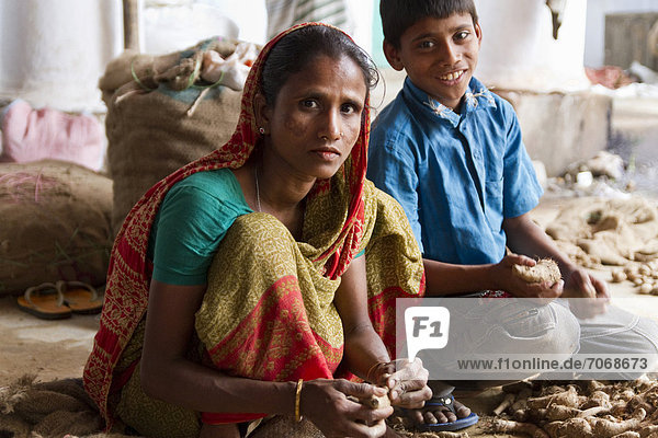 Woman and a boy sorting roots  spice market  Old Dhaka  Dhaka  Bangladesh  South Asia