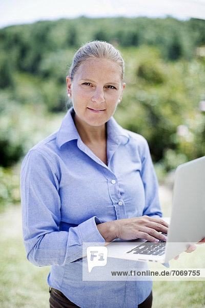 Portrait einer selbstbewussten Geschäftsfrau mit Laptop