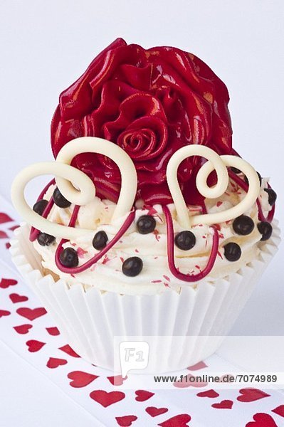 Cupcake mit Herzen und roter Rose zum Valentinstag