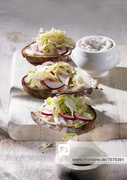 Brown bread topped with dripping and pointed cabbage salad