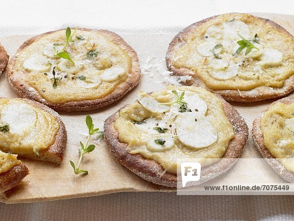Mini pizzas topped with Jerusalem artichokes and Jerusalem artichoke puree
