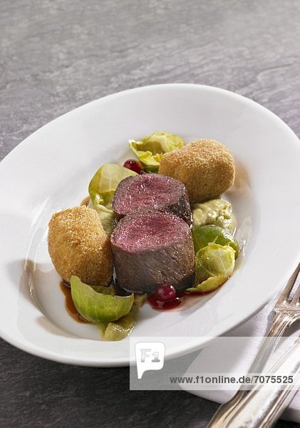 Venison fillets with potato croquettes  Brussels sprouts puree and lingonberries