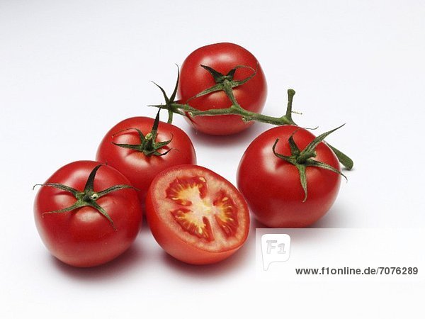 Vier ganze & eine halbe Tomate vor weissem Hintergrund