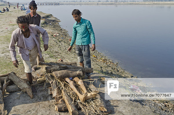 Eine Leiche wird auf Brennholz am Ufer des Yamuna als Teil der Einäscherungszeremonie gelegt  Vrindavan  Indien  Asien