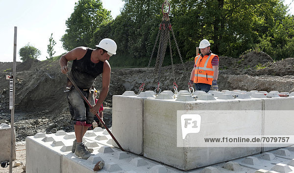 Bauarbeiter setzen erste Steine f¸r eine Baugrund-Probebelastung  auf einer Baustelle in Fridolfing  Bayern  Deutschland  Europa