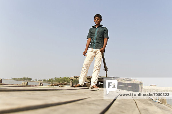 Junger Fährmann steuert sein Holzboot  Gabura  Sundabarns  Khulna District  Bangladesch  S¸dasien