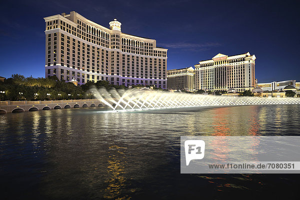 Night shot  trick fountains  Bellagio  Caesars Palace  The Mirage  luxury hotels and casinos  Las Vegas  Nevada  USA  PublicGround