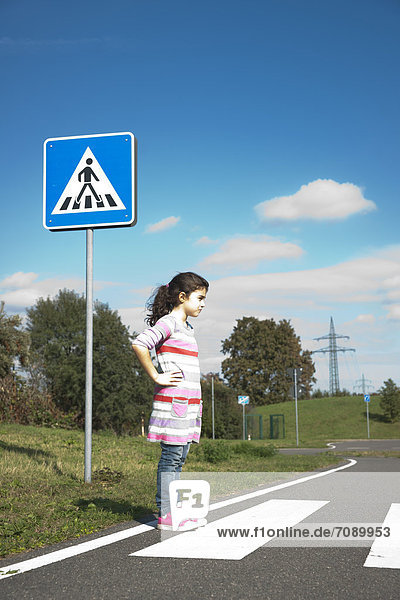 Mädchen wartet an einem Zebrastreifen auf einem Verkehrsübungsplatz
