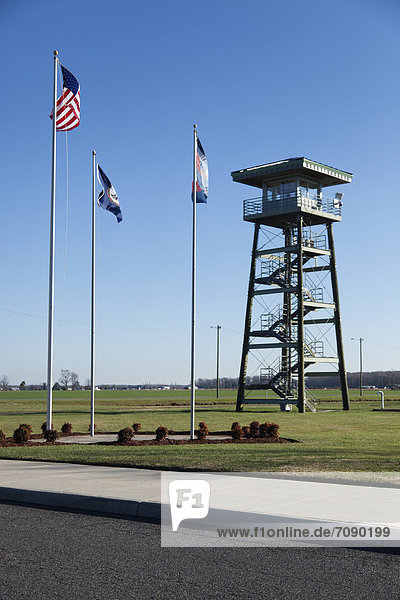The watch tower of a Correctional Facility. Prison entrance  with flagpoles.