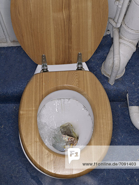 Euro-Schein in der Toilettenschüssel
