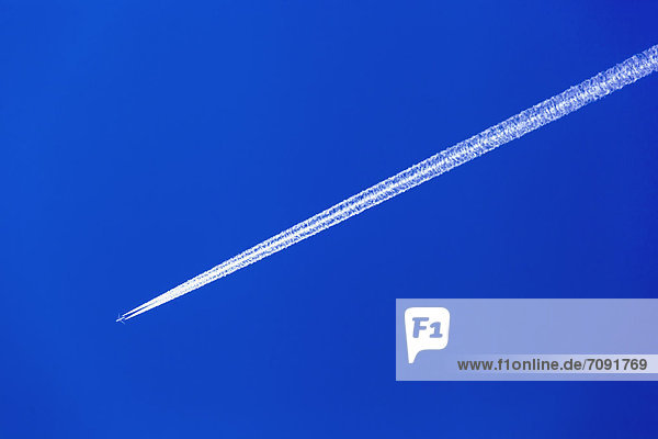 Austria  Aeroplane with contrail against blue sky