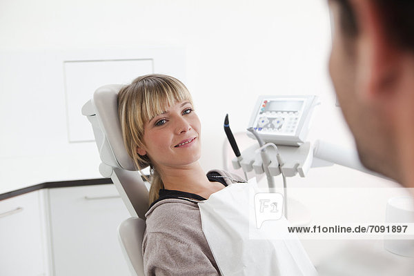 Germany  Young woman in dentist chair  smiling