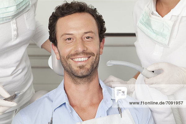 Deutschland  Mittlerer Erwachsener Mann  der seine Zähne vom Zahnarzt untersuchen lässt