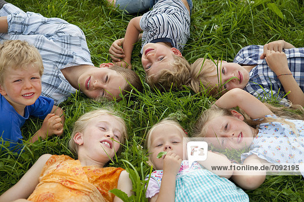 Germany  Bavaria  Group of children lying in meadow