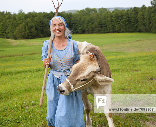 Mature woman with cow on farm