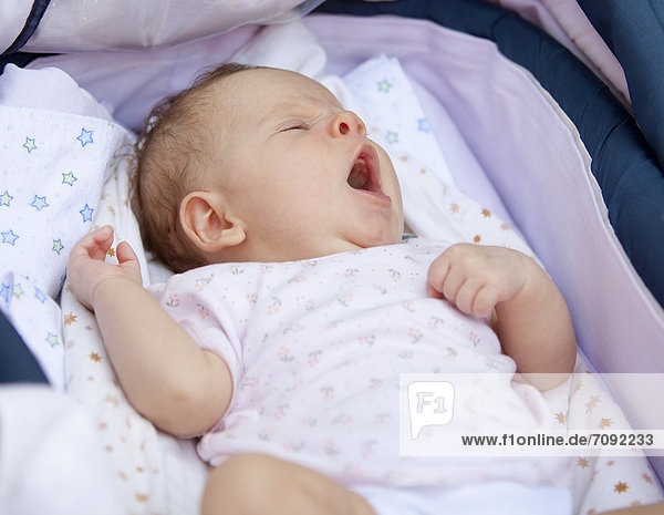 Baby girl in crib yawning