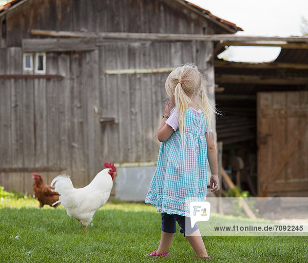 Mädchen mit Huhn auf dem Bauernhof
