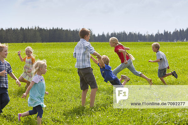 Germany  Bavaria  Group of children playing in meadow