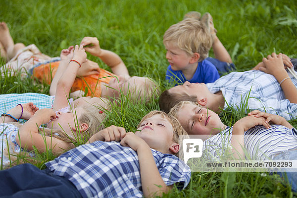 Germany  Bavaria  Group of children lying in meadow