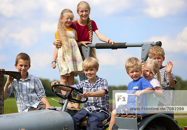 Deutschland  Bayern  Kindergruppe im alten Traktor sitzend