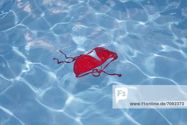 Deutschland  Rotes Bikini-Top schwimmend im Schwimmbad