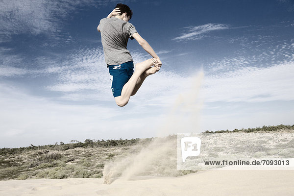 Frankreich  Teenager Junge springt auf Sanddüne