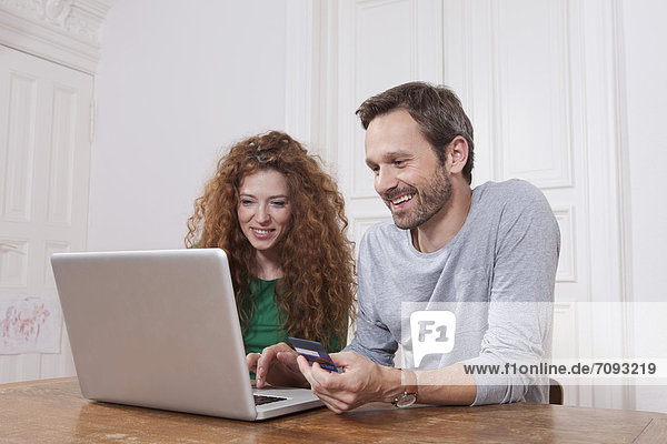Deutschland  Berlin  Paar mit Laptop für Homeshopping